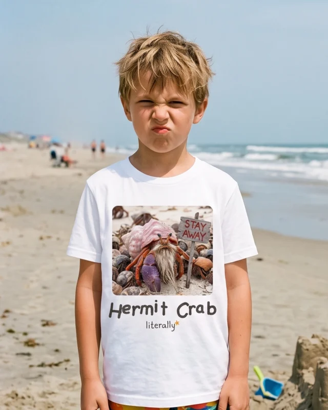 Boy making a grumpy face on the beach wearing the white literally Hermit Crab photo t-shirt